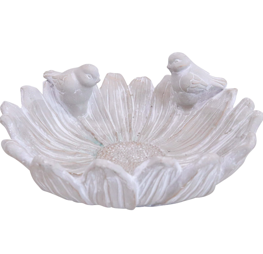 A concrete bird water bath designed with a flower shape and two birds perched on the edges.