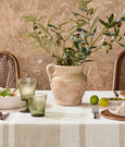 Chari Pot Stone on dining table filled with olive branches