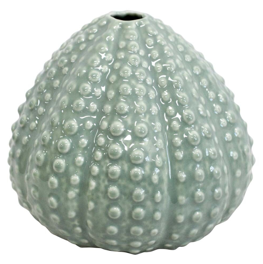 A close-up of a rounded, ceramic bud vase with a textured, spiky surface resembling a sea urchin. The vase is a soft, muted green-grey colour with a glossy finish.