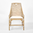 A dining chair with a frame made of light-coloured bamboo. The backrest is tall with a woven rattan insert and an arched top detail. The seat is a light, natural-coloured fabric cushion. The chair has armrests and a high back. Front view