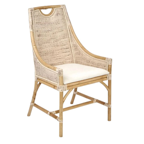 A dining chair with a frame made of light-coloured bamboo. The backrest is tall with a woven rattan insert and an arched top detail. The seat is a light, natural-coloured fabric cushion. The chair has armrests and a high back.
