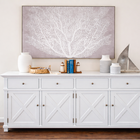 White Hamptons style buffet sideboard with cross panel doors styled with coastal artwork and ceramic decor
