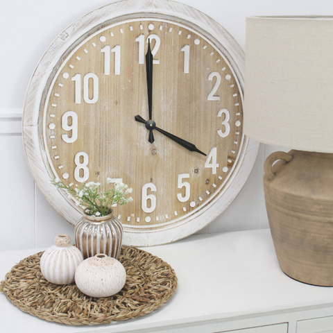 Hamptons style rustic wall clock with natural timber face styled on a console with ceramic lamp and coastal décor