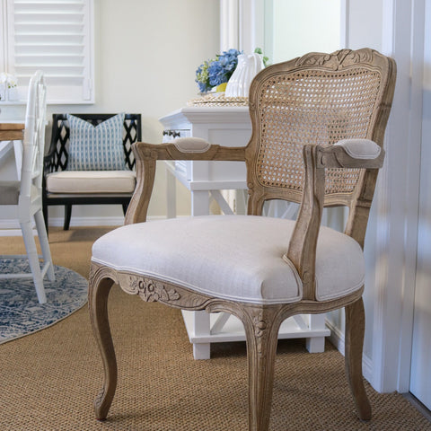 Hamptons style dining chair with carved timber frame, rattan back and upholstered seat in coastal dining room