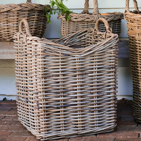 Woven rattan storage baskets with handles styled outdoors in a Hamptons style home