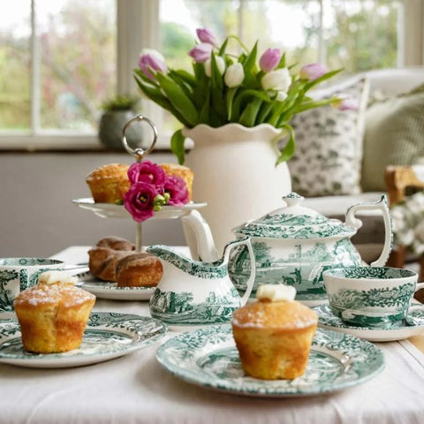 Spode Heritage Green Italian tea set with teapot, teacups, plates and afternoon tea treats styled on a coastal dining table with fresh tulips