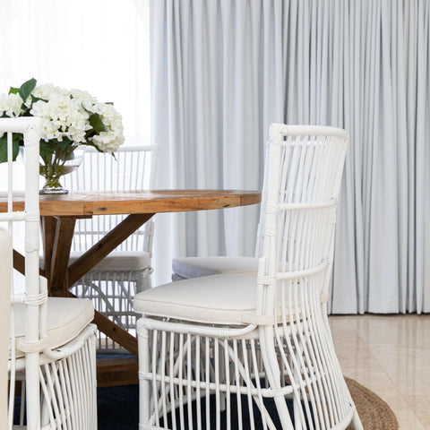 White rattan dining chairs with timber table in Hamptons style dining room