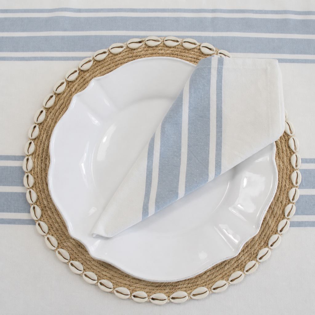 Bay Stripe coastal tablecloth styled with shell seagrass placemat, white dinner plate, and blue striped napkin for relaxed coastal dining