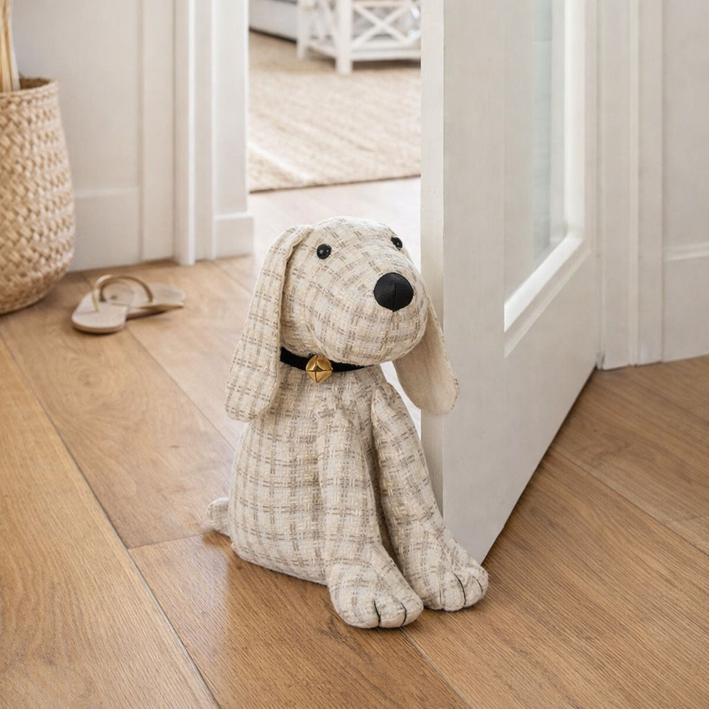 Fabric dog door stop styled at a doorway in a light Hamptons-style home with timber floors.