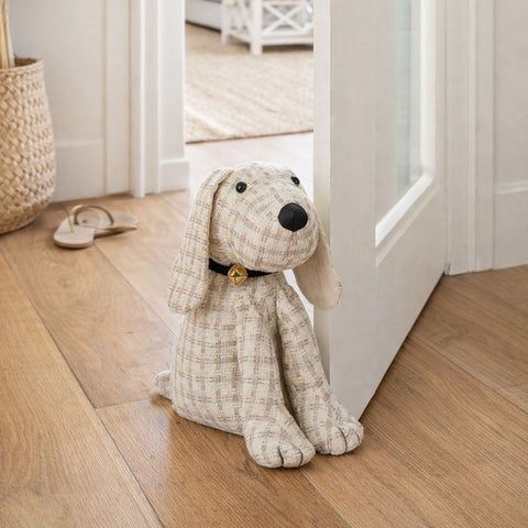 Fabric dog door stop styled at a doorway in a light Hamptons-style home with timber floors.