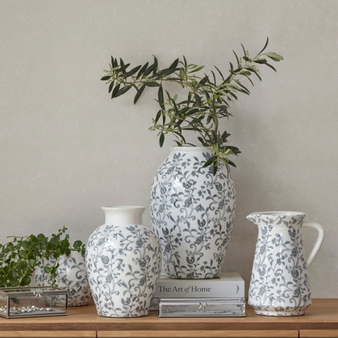 Blue and white ceramic decorative vases styled with olive branches on a timber console table