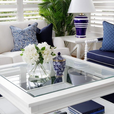 Hamptons style living room with white coffee table, blue cushions, coastal table lamp and classic upholstered seating
