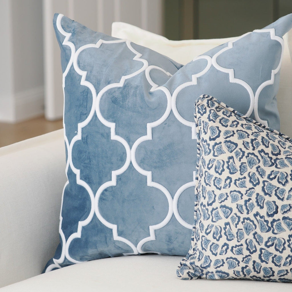 Malibu Ocean blue velvet cushions styled on a white sofa with a blue and white patterned cushion
