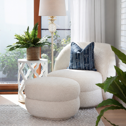 Hamptons style floor lamp beside a boucle occasional chair with navy cushion in a bright coastal living room