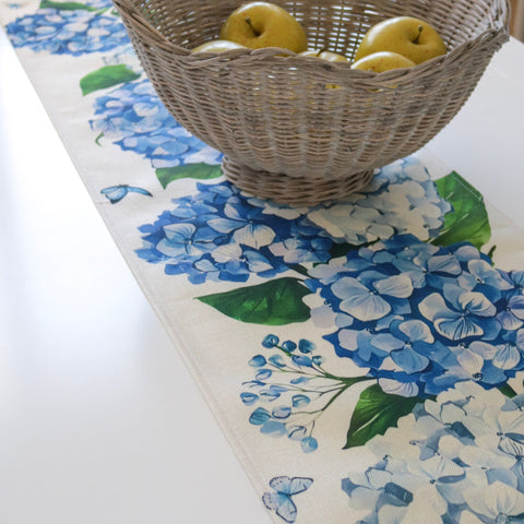 Coastal hydrangea table runner styled with woven basket and fresh fruit on a Hamptons-inspired dining table