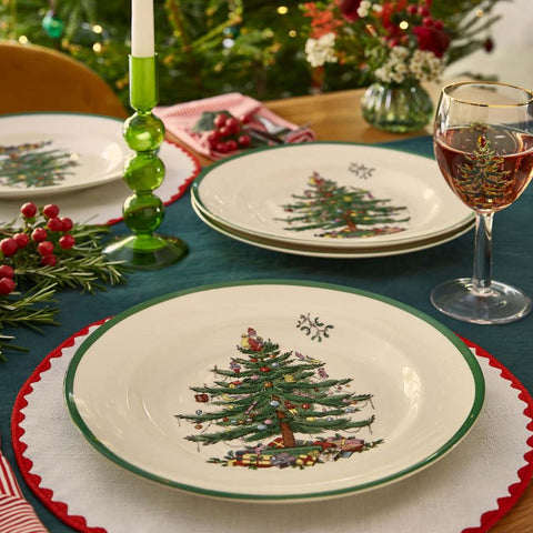 Spode Christmas Tree dinner plates styled on a festive table setting with holiday décor, candles and glassware.