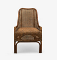 A natural brown rattan dining chair with a high, slightly curved backrest and armrests. The back and seat are both made from tightly woven rattan, and the chair has a classic, elegant silhouette.
