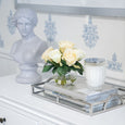 Arch handle mirrored tray styled on a white console with books, candle and floral arrangement