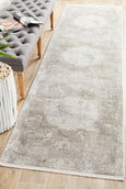 Arley Stone Runner with stone-toned distressed medallion pattern in neutral hues displayed in a hallway.
