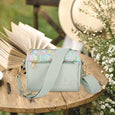 Beatrix Potter Peter Rabbit Crossbody Bag on an outdoor table with book 