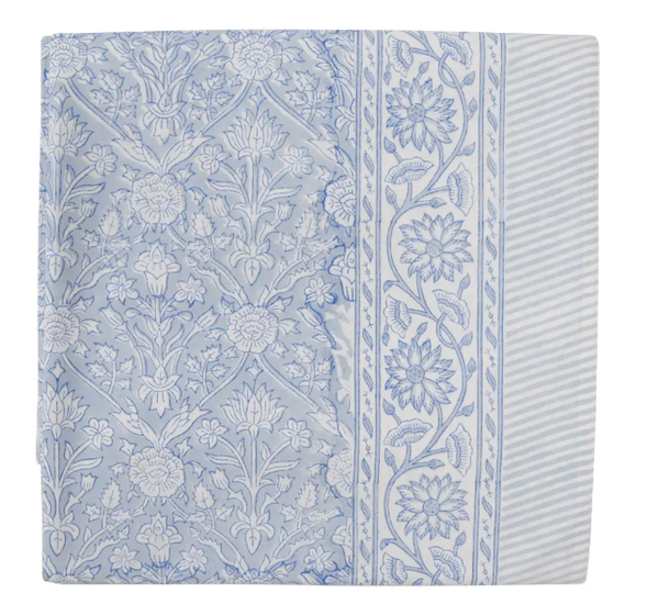 Belvedere Blue tablecloth in hand block printed cotton with blue floral pattern and striped border on a Hamptons-style dining table