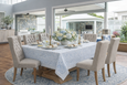 Belvedere Blue tablecloth in hand block printed cotton with blue floral pattern and striped border on a Hamptons-style dining table