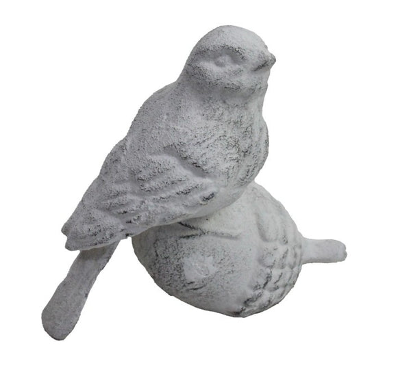 White iron bird ornament perched on acorn decorative sculpture