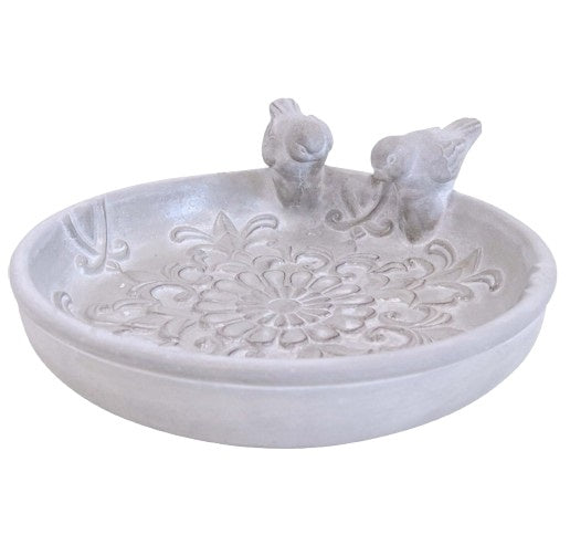 A concrete bird bath tap bowl with floral patterns and two bird figurines on the edge.