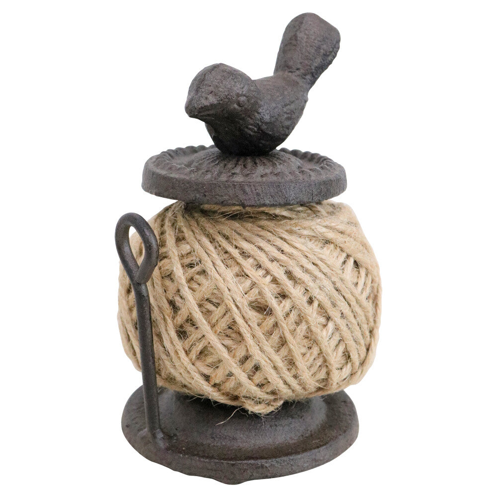 Decorative spool of twine with a bird on top on a white background