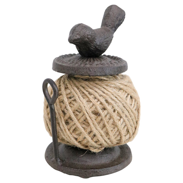 Decorative spool of twine with a bird on top on a white background