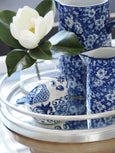 Blue and white ceramic jug styled with coordinating porcelain décor on a mirrored tray