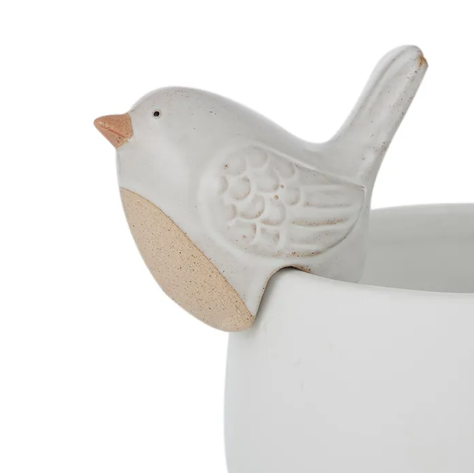 White ceramic bird pot hanger perched on the edge of a planter