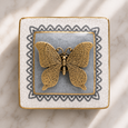 Butterfly Grey Trinket Box with antique gold butterfly lid detail, grey crackle glaze and decorative border on marble surface.
