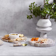 Round white and beige marble serving board with natural stone veining