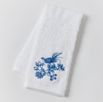White cotton hand towel with blue embroidered Chinoiserie bird and floral design.