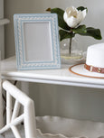 Blue and white coastal ceramic photo frame styled on bedside table
