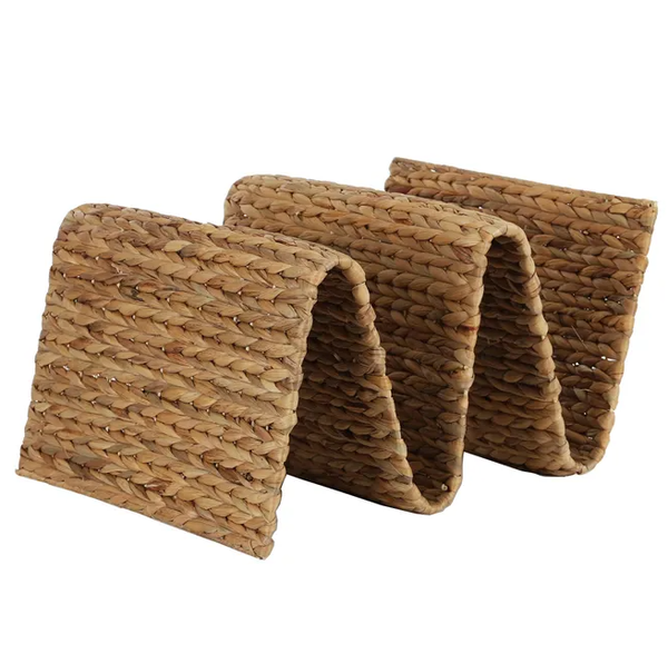 Natural water hyacinth woven magazine rack with sculptural wave design.