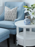White round side table styled beside blue armchair with ceramic décor