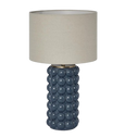 Blue ceramic table lamp with raised spherical base and linen shade on white background