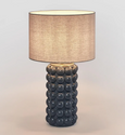 Blue ceramic table lamp with raised spherical base and linen shade on white background