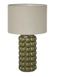 Green ceramic table lamp with raised spherical base and linen shade on white background