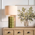 Condetti green table lamp styled on a timber console in a Hamptons-style interior with botanical artwork