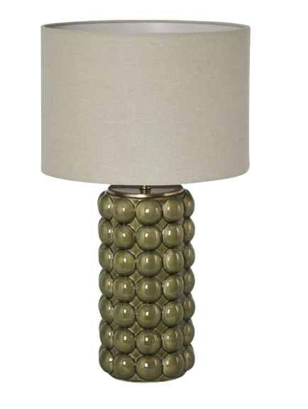 Green ceramic table lamp with raised spherical base and linen shade on white background