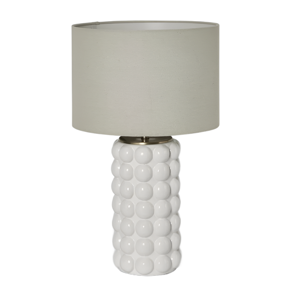 White ceramic table lamp with raised spherical base and natural linen shade on white background