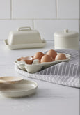 Cream butter dish styled with egg holder and striped linen