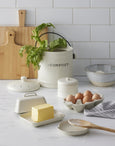 Stoneware butter dish cream styled with compost crock and kitchen accessories