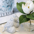 Decorative white birds and a large white flower on a surface with a blurred background