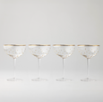 Set of four coupe glasses with raised gold dots and gold rim, elegant glassware for champagne and cocktails.