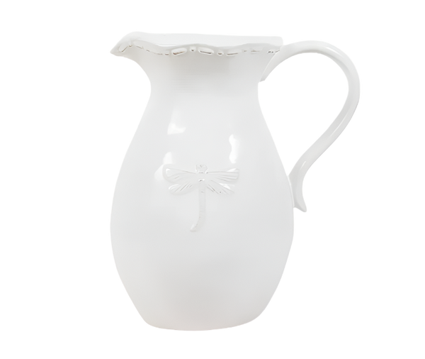 White stoneware jug with raised dragonfly detail and curved handle, styled in a coastal Hamptons interior.