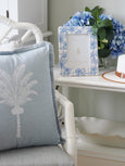 Blue and white Hamptons palm photo frame styled on coastal bedside table